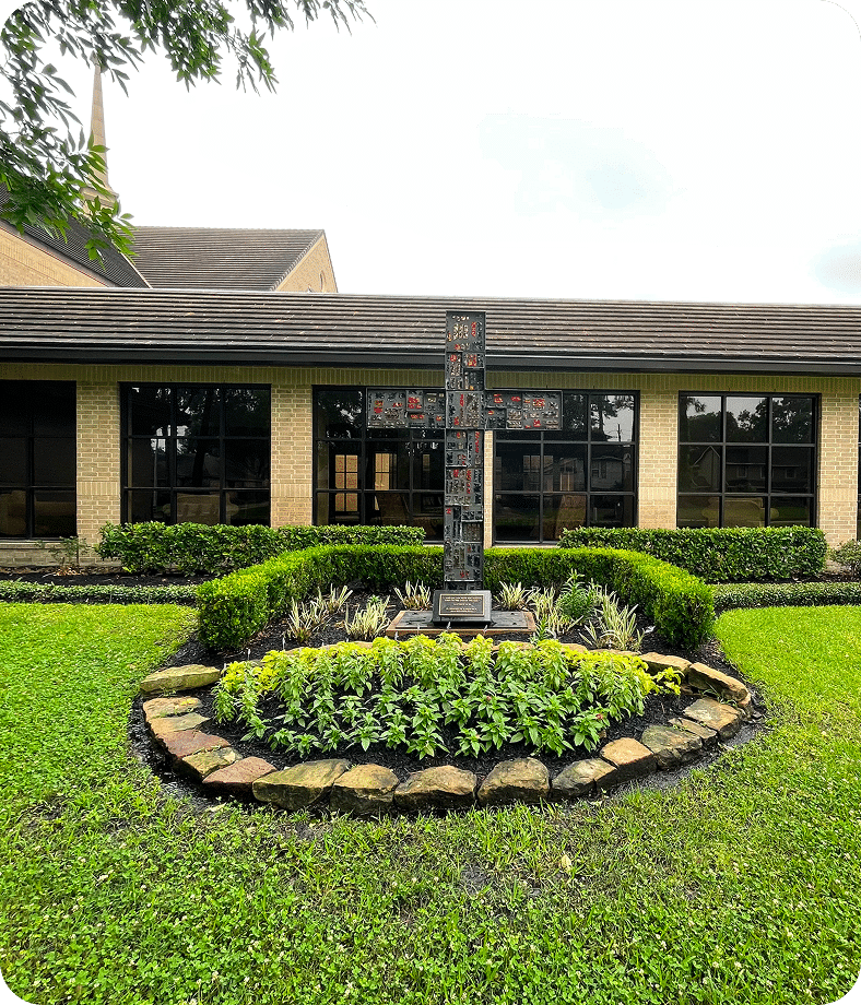 Decorative cross in landscaped courtyard