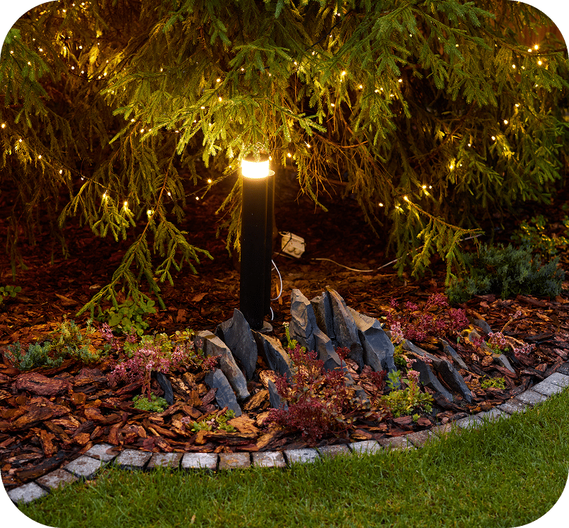 a bollard light illuminating a garden bed
